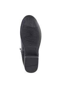 Footwear negro con suela de goma texturizada, que cuenta con estrías para tracción y una superficie lisa. Incluye detalle de cremallera lateral.