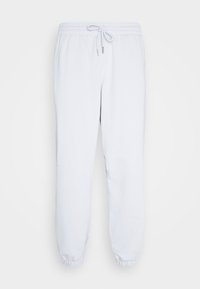 Svetle modré tepláky vyrobené z měkké látky, s elastickým páskem se šňůrkou, zúženými nohavicemi a elastickými manžetami na kotnících.