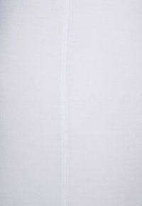 Bijela rebrasta tkanina s glatkom teksturom, koja ima vertikalnu šav usred. Materijal je lagan i rastezljiv.