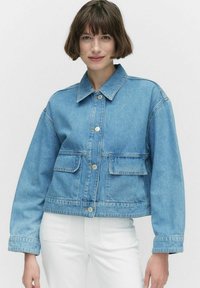 Vaaleansininen denim-takki, jossa on kauluksellinen kaula, etupocketit ja hopeiset napit. Ominaisuuksia ovat lyhyt malli ja rento istuvuus.