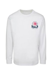 Hvid langærmet T-shirt med et brystgrafik, der viser en pink sol, bølger og teksten "SUNSET CHARM" i blå. Blødt bomuldsstof.