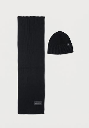 Czarny zestaw szalika i czapki. Szalik ma prążkowaną fakturę, podczas gdy czapka ma podwinięty brzegi. Oba elementy mają prosty, jednolity design.