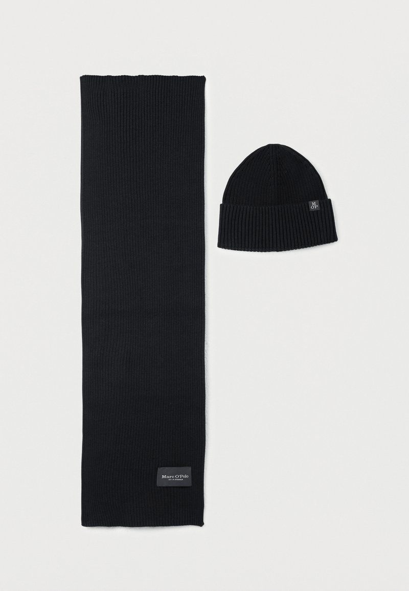 Zwarte gebreide sjaal en muts set. De sjaal heeft een geribbelde textuur, terwijl de muts een eenmaal omgeslagen boord heeft. Beide items hebben een eenvoudig, effen ontwerp.