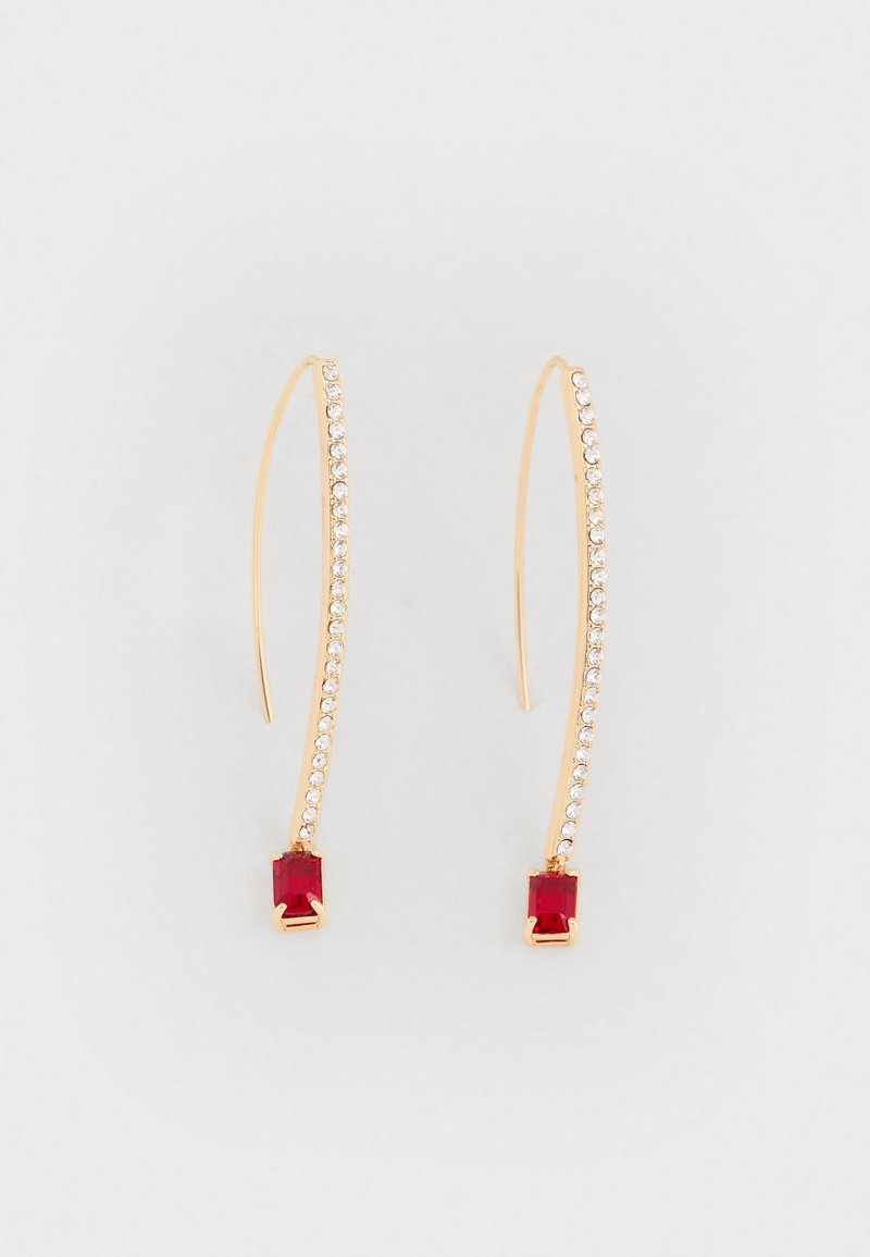 Aranyszínű fülbevalók, amelyek íves, hosszúkás kialakítással rendelkeznek, és tiszta rhinestone-ok díszítik őket, az alján pedig egy négyzet alakú piros drágakő található.