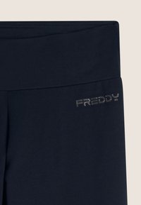 Leggings in jersey blu navy con un ampio elastico in vita. Presentano un logo argento "FREDDY" sull'anca. Texture liscia e design aderente.