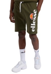 Alyvuogių spalvos šortai su baltu "ellesse" logotipu ir oranžiniu akcentu. Dėvimi su baltais sportbačiais ir baltomis kojinėmis, atitinkančiomis prekės ženklo logotipą.