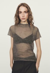 Grijs doorschijnend topje met korte mouwen en een hoge halslijn, gelaagd over een donker beha, met een zachte, lichte textuur en een ontspannen pasvorm.