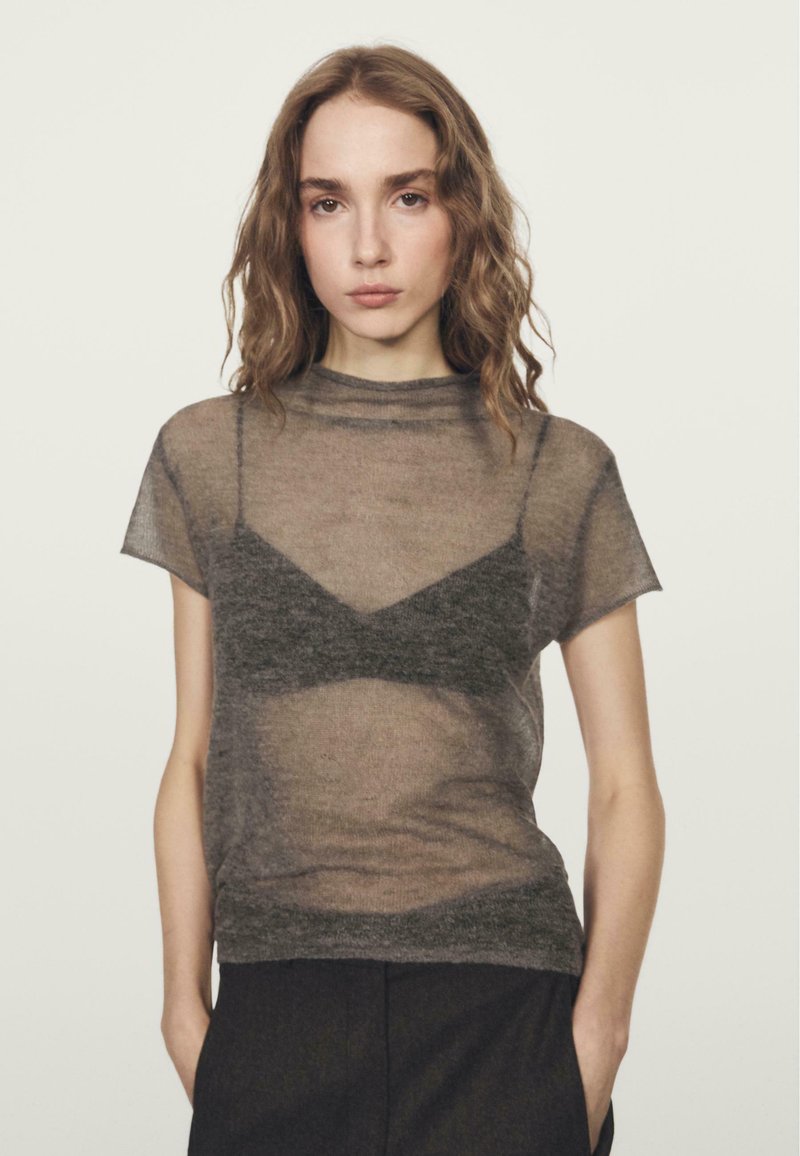 Grijs doorschijnend topje met korte mouwen en een hoge halslijn, gelaagd over een donker beha, met een zachte, lichte textuur en een ontspannen pasvorm.