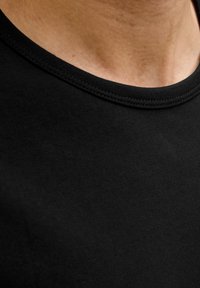 Sort bomulds T-shirt med rund halsudskæring og glat tekstur, med fint syede kanter og en tætsiddende design.