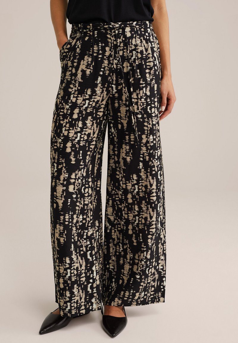 Pantalons à jambes larges en tissu noir avec un motif abstrait crème. Matière légère avec une taille à cordon et des poches latérales.