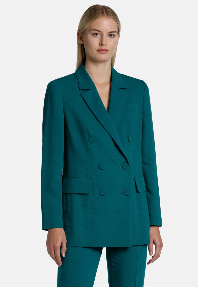Teal double-breasted blazer in textured fabric, featuring two large front buttons, notched lapels, and side pockets. Structured silhouette.