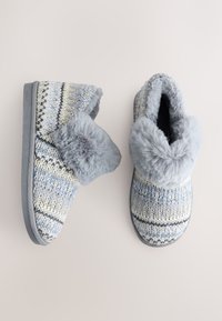 Chaussons gris avec dessus en tricot aux rayures bleu clair, crème et marine, dotés d'un col en fausse fourrure et d'une semelle en caoutchouc antidérapante.
