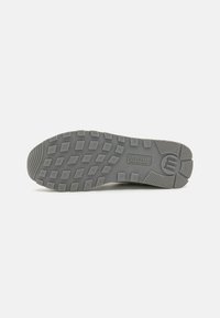 Semelle de chaussure en caoutchouc gris arborant un motif de traction robuste avec des formes hexagonales et en diamant pour une adhérence et une traction améliorées.