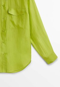 Lime green long-sleeve shirt with a single chest pocket, button-down front, curved hem, and a slightly crinkled texture.