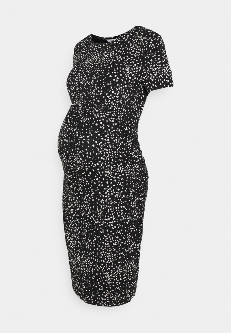 Robe de maternité noire avec petit motif floral blanc, manches courtes et silhouette ajustée mettant en valeur le ventre arrondi.