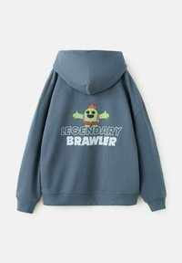 Hanorac albastru închis cu glugă, cu un personaj de desene animate verde și text alb pe spate care spune "LUPTĂTOR LEGENDAR".