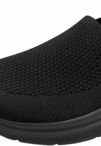 Schwarzer Slip-On-Schuh mit strukturiertem Strickobermaterial und dicker, gemusterter Sohle, entworfen für Komfort und einfaches Anziehen.