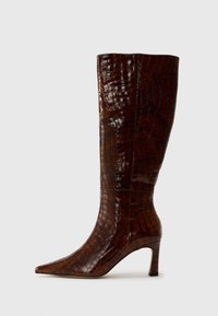 Botte à genoux en cuir d'alligator brun avec un bout pointu, un talon fin et une finition texturée, présentant une surface brillante et des coutures minimales.