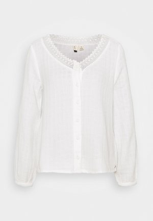 Hvid langærmet bluse i tekstureret stof med rund halsudskæring med blonder, knaplukning foran og elastiske manchetter.