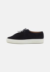 Schwarze Wildledersneaker mit runder Schuhspitze, weißer Gummisohle und passenden Schnürsenkeln. Verfügt über dezente Markenkennzeichnung an der Seite. Minimalistisches Design.