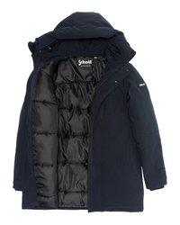 Abrigo de invierno acolchado en azul marino con capucha fija, cremallera y botones a presión, mostrando el forro interior de tejido negro acolchado y la etiqueta de la marca Schott.