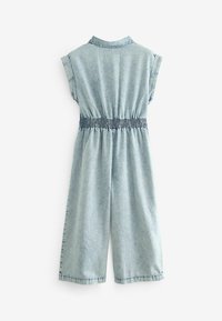 Ljusblå denim jumpsuit utan ärmar med elastisk midja och vida ben, visad bakifrån mot en vit bakgrund.