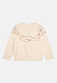 Krémová mikina s květinovým volánkovým výstřihem, dlouhými rukávy a zapínáním na knoflík na zadní straně. Měkká textura, žebrované manžety a pas.