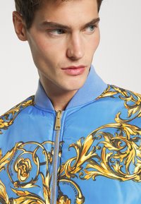Versace Jeans Couture PRINTED GARLAND - Blusão aviador - blue/gold