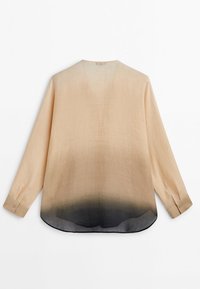 Blouse beige à manches longues avec un ourlet foncé en dégradé, poignets boutonnés et bas arrondi, présentée à plat sur fond blanc.