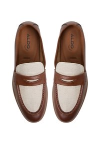 Brown leather loafers with a beige fabric upper, featuring a strap across the instep and visible stitching around the edges.
