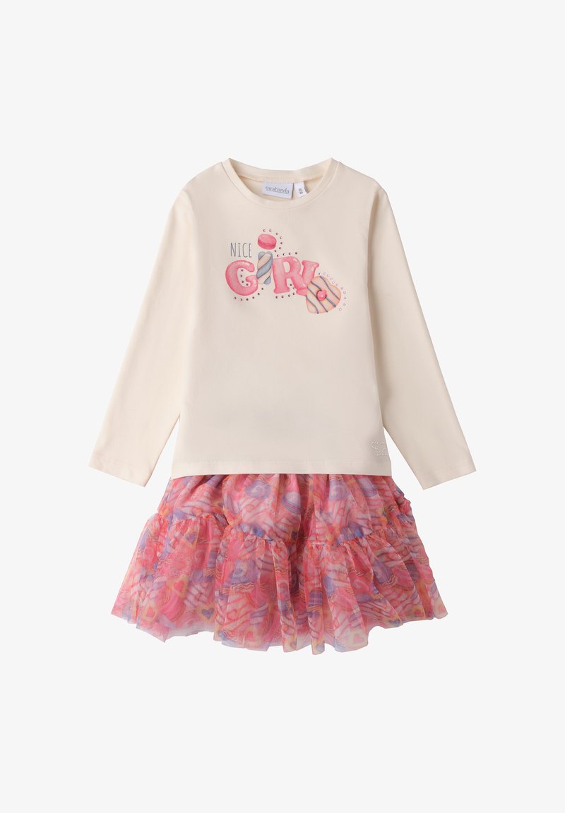 Langärmliges cremefarbenes Oberteil mit dem Aufdruck "NICE GIRL" und rosa Marshmallow-Akzenten, kombiniert mit einem mehrlagigen Tüllrock in pink und lila mit Muster.