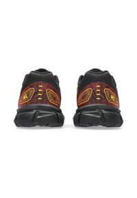 Baskets de sport noires avec accents rouges et tige en mesh. Présentent des surcouches texturées, des détails réfléchissants et une semelle rembourrée pour le soutien.