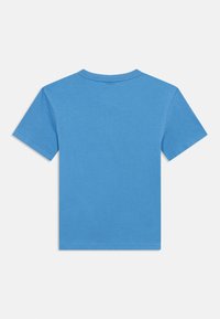 Μπλε βαμβακερό μπλουζάκι με κοντά μανίκια, στρογγυλή λαιμόκοψη και απλό πίσω μέρος. Λείος υφασμάτινος χαρακτήρας και ομοιόμορφη ραφή κατά μήκος των άκρων.