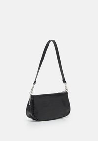 Sac à main en cuir noir gaufré crocodile avec une forme courbée, doté d'une fine bandoulière et de quincaillerie en métal argenté. Fermeture éclair en haut.