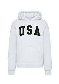 Biela mikina s predným kengurím vreckom, so silným čiernym nápisom "USA" v veľkých písmenách naprieč hrudníkom. Mäkká textura a štandardné strih.