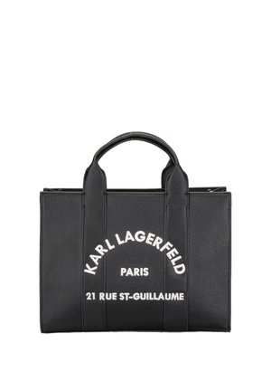 Czarna skórzana torebka z uchwytami u góry z białym napisem "Karl Lagerfeld Paris 21 Rue St-Guillaume" z przodu.
