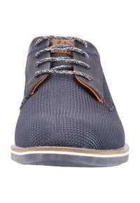 Baskets en maille bleu marine avec des accents en cuir, dotées de lacets gris clair, d'une semelle plate avec une bande marron clair et d'une surface supérieure texturée.