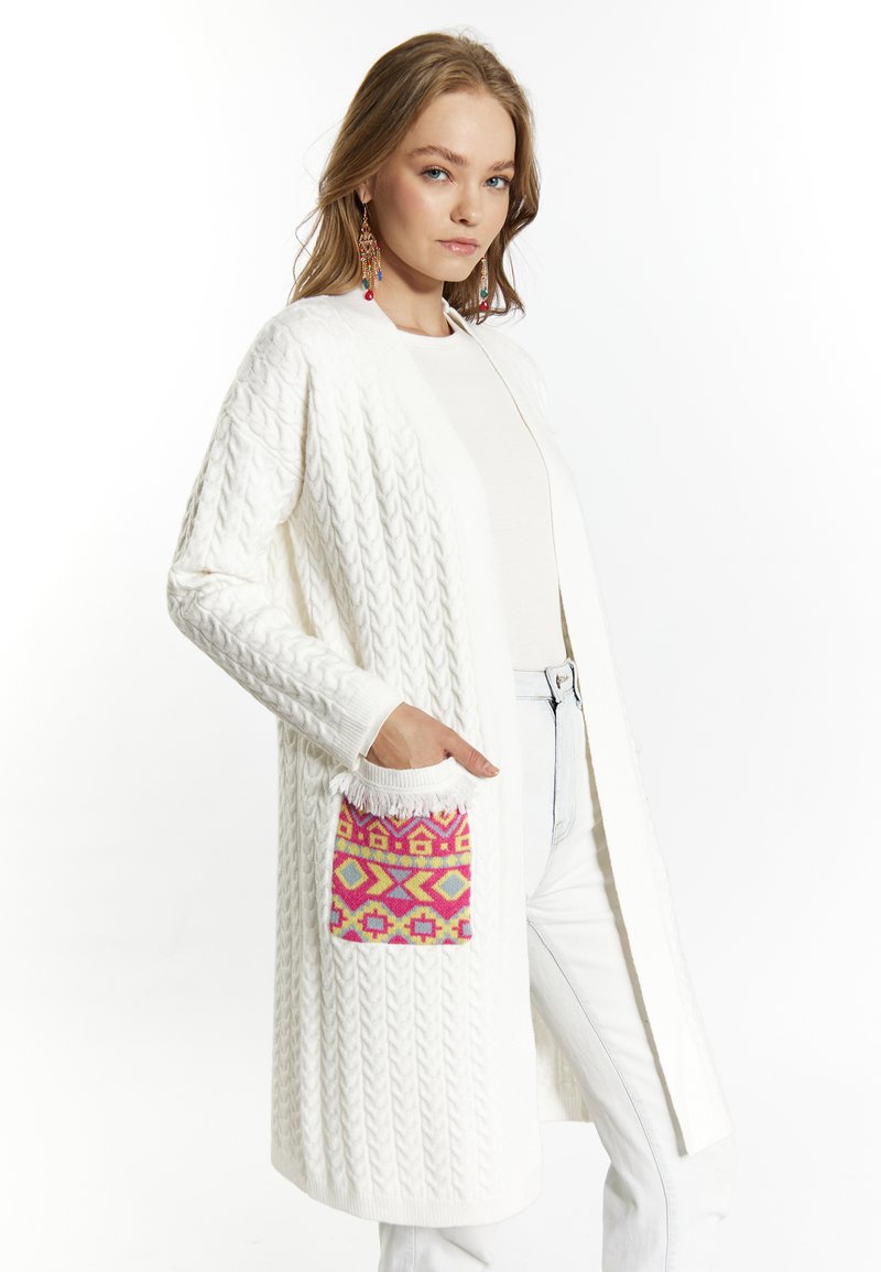 Cardigan bianco lavorato a maglia con un design a cavo testurizzato, caratterizzato da una tasca decorata con un vivace motivo nei colori rosa, giallo e viola. Maniche lunghe e apertura frontale.