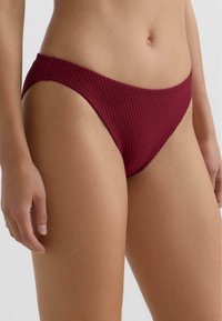 Bordó bikini hlačke z teksturirano tkanino z diamantnim vzorcem. Dizajn ima nizko pasovno linijo in gladke robove.