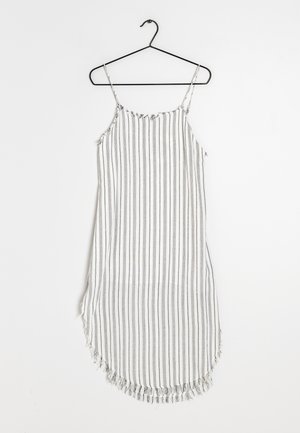 Vestido sin mangas a rayas en una percha negra. Hecho de una tela ligera con rayas verticales en gris y blanco, con un dobladillo con flecos.