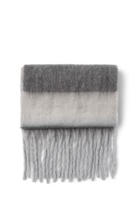 Wełniany szalik w odcieniach szarości i jasnoszarości, z gradientowym wzorem i frędzlami na końcach. Miękka tekstura o gładkim wykończeniu.