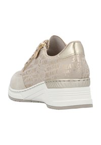Beiger Sneaker mit gemustertem Textil-Obermaterial, Reißverschlussdetails und einem leichten Absatz. Abgesetzt mit metallicfarbigen Akzenten und einer weißen Sohle.