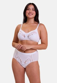 Ensemble de lingerie blanche comprenant un soutien-gorge avec des détails en dentelle et des bretelles réglables, accompagné de culottes taille haute ornées d'accents en dentelle.