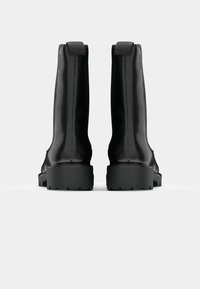 Black leather ankle boots with a matte finish, featuring a chunky black rubber sole and pull tabs on the heel for easy wear.