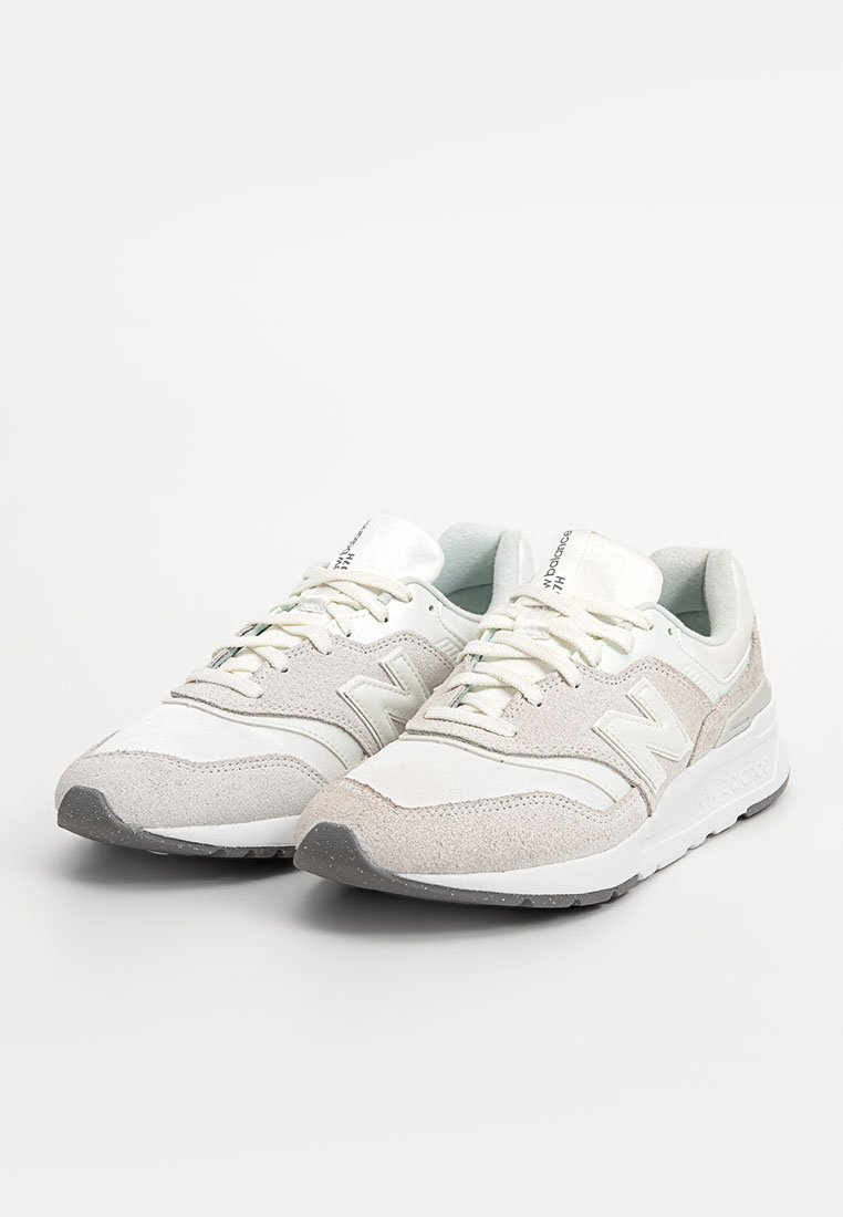 Sneaker atletiche grigio chiaro e bianche, realizzate in suede e mesh, caratterizzate da un colletto imbottito, chiusura con lacci e una suola in gomma testurizzata.