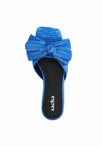 Blauwe slip-on sandaal met een textuurmateriaal en grote strikaccent. Vlakke zool met zwarte binnensoez en de merknaam "sacha" gedrukt.