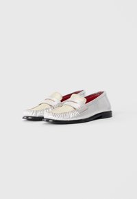 Loafers in silver and cream leather with a stitched moccasin design, featuring a smooth texture and a red interior lining. Black rubber sole.