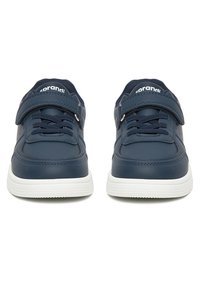 Zapatillas azul marino con suelas blancas, correas de velcro ajustables y cordones a juego, vistas desde el frente sobre un fondo blanco.