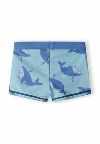 Shorts de bain bleus présentant un motif de baleine sur un fond bleu clair, avec une taille bleu uni et une bordure bleu foncé.