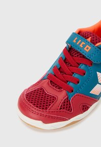 Chaussure de sport bleue et rouge avec tige en mesh, semelle en caoutchouc et accents orange. Elle dispose de lacets et d'une sangle Velcro pour un ajustement sécurisé.